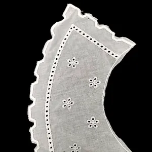 Macro detail view of white cotton eyelet embroidery lace collar with floral patterns