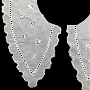 Macro view of white cotton embroidered eyelet collar with delicate floral patterns