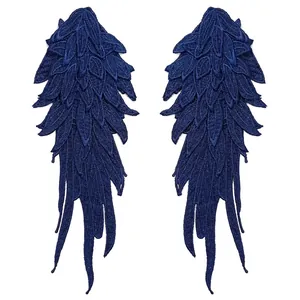 Detailed view of navy blue embroidered angel wing patches with layered lace texture
