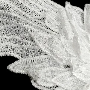 Detailaufnahme der Textur eines weißen bestickten Engelsflügel-Spitzenaufnähers