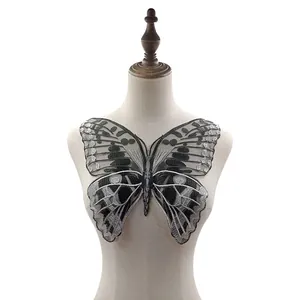 Detailed view of large silver and black butterfly embroidery patch on mesh for DIY sewing projects
