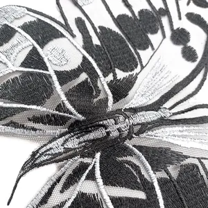 Detailed close-up showing silver and black butterfly embroidery on fine mesh fabric base