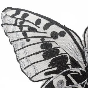 Detailed close-up macro view of silver and black butterfly embroidery patch on mesh base