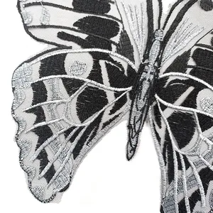 Detailed view of a black and silver butterfly embroidery patch with delicate mesh base.