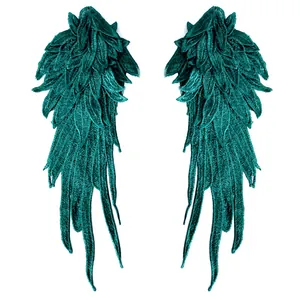 Close-up detail of dark green embroidered angel wing lace patches for DIY crafts