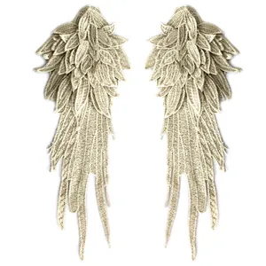Detailed view of beige embroidered angel wing lace appliqués for DIY sewing projects