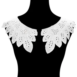 Macro detail of white embroidered cotton lace collar with perforated flower patterns