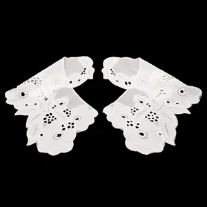 Macro detail view of white cotton eyelet embroidered lace collar with floral patterns