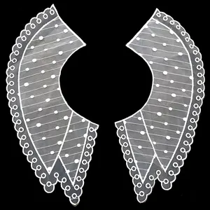 Detailed view of white organza lace embroidered collar with polka dots and wavy edges