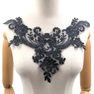 Detailaufnahme der aufwendigen schwarzen Kordelspitze mit floraler Stickerei auf Netz.