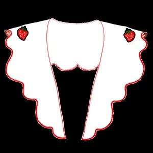 Macro view of white lace collar featuring red scalloped edges and strawberry embroidery