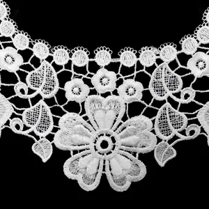 Macro detail of white floral embroidery lace collar showing delicate hollow-out pattern.