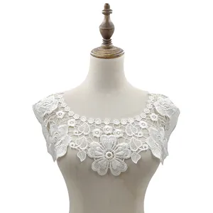 Detailed macro view of white floral embroidered lace collar on a mannequin