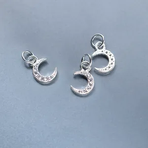 Close-up of three 925 sterling silver plated crescent moon charms with clear CZ inlay detail