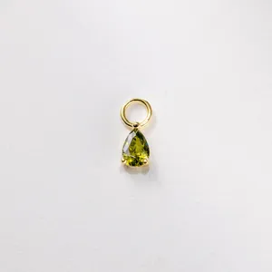Dettaglio di un ciondolo con gemma verde a forma di pera e anello in argento sterling dorato.