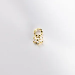 Primo piano di un piccolo ciondolo a fiore placcato oro 18K con cristalli