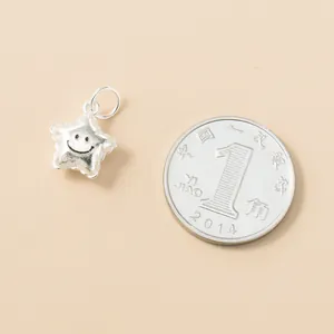 Vue détaillée du pendentif étoile smiley en argent 925 avec une pièce pour référence