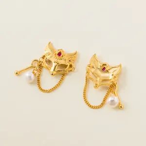 Detalle de dije de máscara de zorro en plata 925 dorada con perla para joyería DIY.