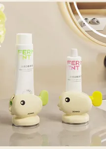 Detail view of a cute whale-shaped toothpaste squeezer in soft yellow on bathroom counter.