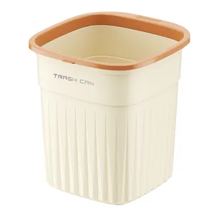 Modern cream-colored trash can with orange press ring and vertical texture