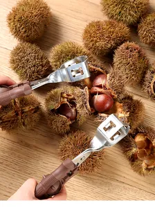 Close-up of a manual chestnut opener tool peeling fresh chestnuts on a wooden surface.