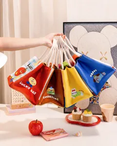 Close-up of various colorful cute canvas lunch bags with thick rope handles and cartoon prints