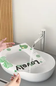 Waterproof EVA toilet seat cover being rinsed under a running faucet for cleaning