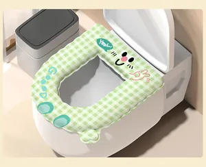 Detail of a cute green checkered waterproof toilet seat cover with cartoon face pattern