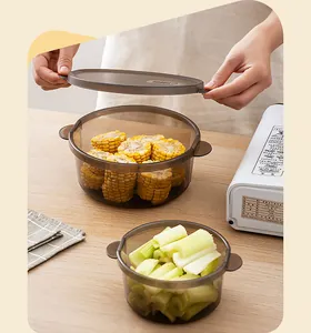 Close-up of translucent brown food storage boxes with corn and celery in a kitchen setting