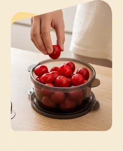 Close-up of a smoke-grey round food storage container filled with fresh cherry tomatoes