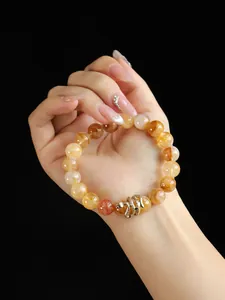 Close-up view of yellow crystal beaded bracelet with golden snake charm on hand