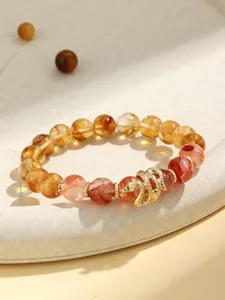 Detailed view of natural crystal beaded bracelet with an elegant golden snake charm