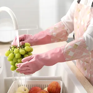 Pink waterproof household cleaning gloves with long sleeves washing grapes in sink