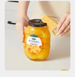 Close-up shot of a multifunctional yellow magnetic bottle opener prying open a large glass jar