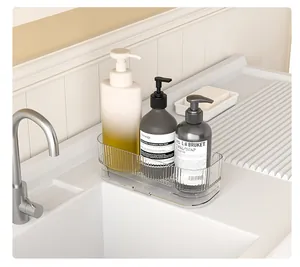Narrow transparent storage rack for kitchen sink holding soap bottles and sponges.