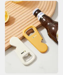 Close-up detail of colorful magnetic bottle openers beside a beer bottle and lemon.