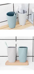 Close-up detail of spiral-textured toothbrush cups in a minimalist bathroom setting