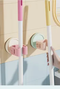 Macro detail of colorful wall-mounted mop holders installed on pastel bathroom tiles