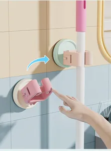 Close-up showing the suction cup mechanism of a wall-mounted mop and broom clip