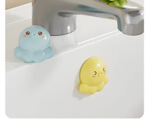 Close-up of yellow octopus overflow hole plug installed in a white bathroom sink