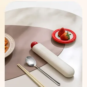 Lifestyle detail of portable cream cutlery case with stainless steel spoon and sticks.