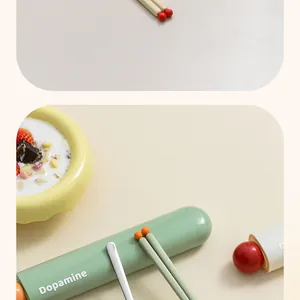 Detail of green portable cutlery storage box with Dopamine branding and stainless steel spoon