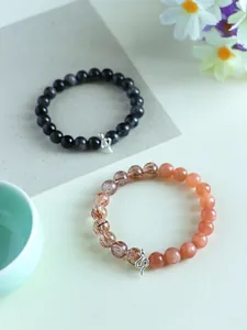 Detail of the 925 silver snake charm on sunstone and black crystal beaded bracelets.