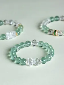 Close-up detail of a green fluorite and clear quartz bow-knot beaded bracelet for women