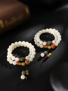 Detaillierte Makroansicht von doppellagigen weißen Bodhi-Samen-Armbändern mit Quasten