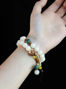 Detailansicht eines zweireihigen weißen Bodhi-Samen-Armbands mit Zierperlen am Handgelenk