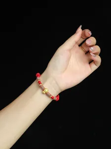 Vue détaillée du bracelet tressé rouge fait main pour l'année du serpent avec porte-bonheur