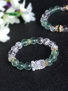 Close-up detail of green fluorite and white quartz beaded bracelet with carved charm