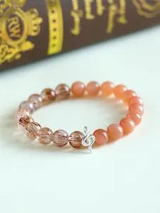 Close-up of 925 silver snake charm on sunstone and rutilated quartz beaded bracelet.