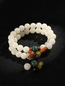 Detailansicht eines weißen Bodhi-Samen-Doppelarmbands mit geschnitzter Lotusperle und Akzenten.